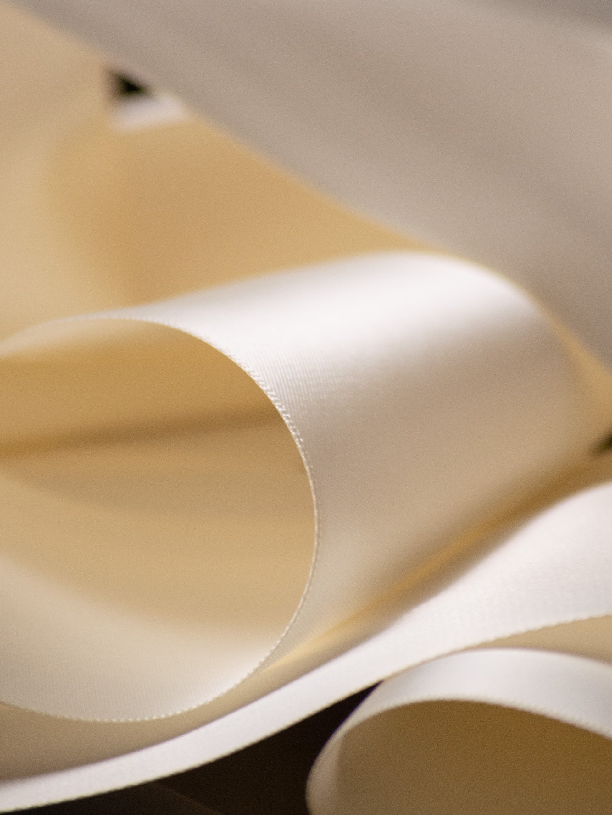 ivory satin ribbon close up, smooth double faced finish with soft luminous sheen